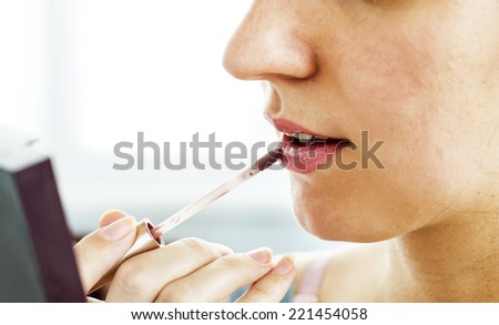 The process of cosmetic paint woman\'s lips on white background