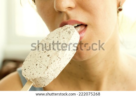 Woman eating white ice cream on a light background