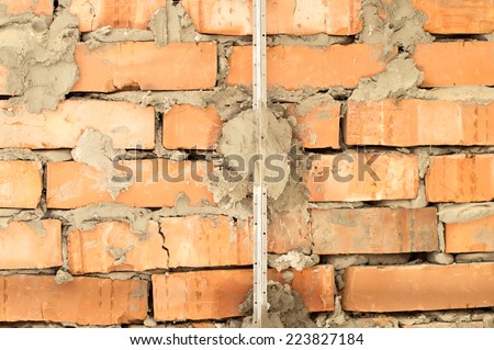 Installation of metal lighthouses on a brick wall - preparation for plaster with cement mortar