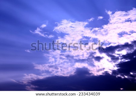 Beautiful white clouds under the light of the Sun against the background of the blue sky