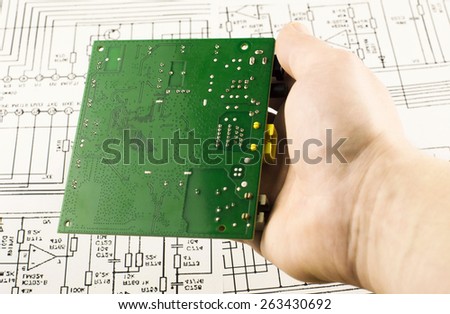 Chip green in hand on background drawings circuits
