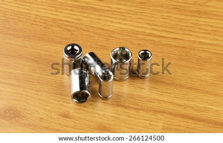 Set of different nozzle to tighten the bolts on the background of the wooden floor