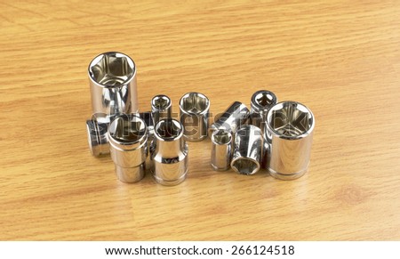 Set of different nozzle to tighten the bolts on the background of the wooden floor