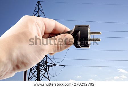 Shtepsel in your hand on a blue background power lines