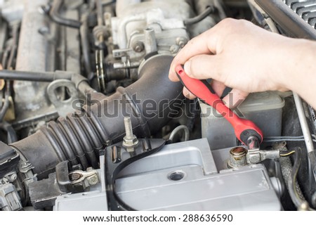 The process of tightening bolts to fix the the vehicle battery