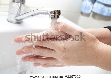Washing of hands with soap under the crane with water