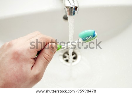 Tooth-paste on a brush against a white washstand