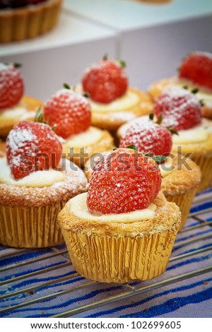 Strawberry cupcakes for sale at a food market.