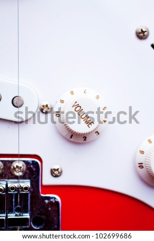 A vintage electric guitar's volume control dial. Focus on 'volume'.