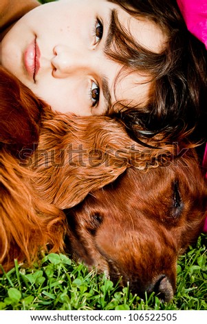 A girl on the grass with her beloved red setter.