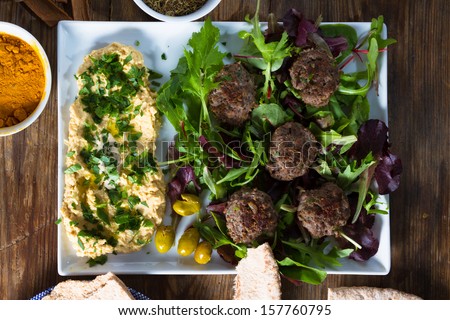 Middle East cuisine: a plate of delicious lamb burgers, olives and hummus.