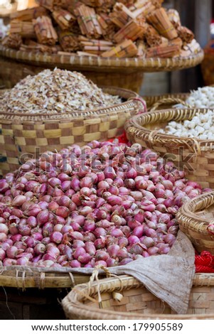 Huge pile of red onions for sale at market in Myanmar (Burma).