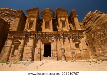 A dog in the doorway of the Monastery, one of the famous monuments of the ancient Nabatean city of Petra, Jordan.