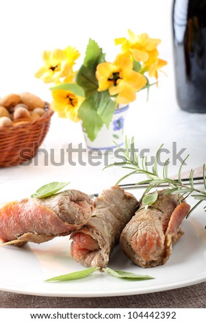 Meat rolls with salami and cheese on complex background