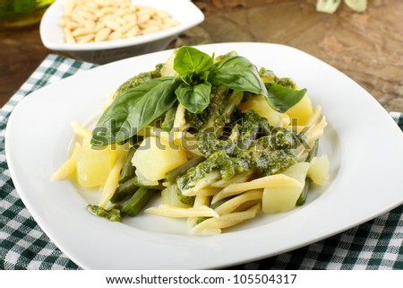 Pasta with pesto, green beans and potatoes on complex background