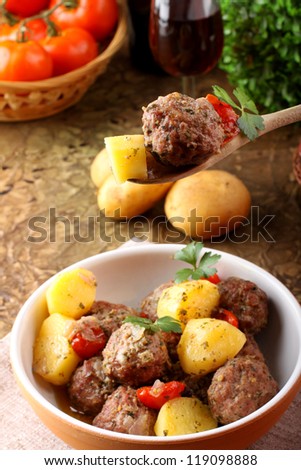 Meatballs with tomato sauce with potatoes in broth on complex background