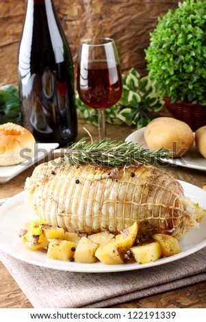 Chicken roll stuffed  with baked potatoes on complex background