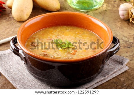 Potato soup with pasta and meatballs on complex background