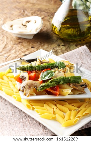 Pasta with fresh tuna, mushrooms and asparagus on complex background