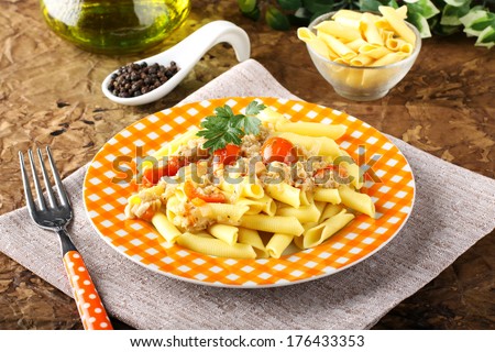 Pasta with crab meat and tomatoes on complex background