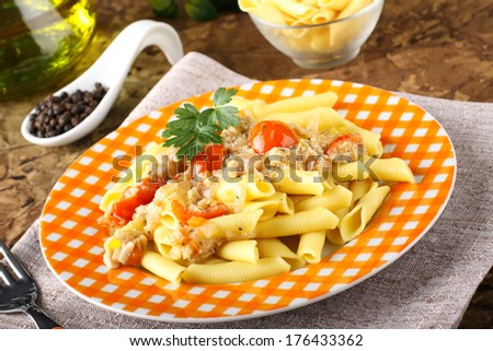 Pasta with crab meat and tomatoes on complex background