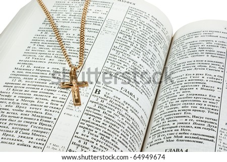Golden cross on the opened russian Holy Bible