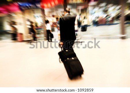 Business man rushing at the airport. Intentional Zoom-effect motion blur.