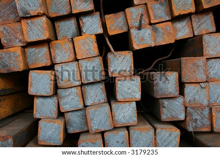 Stacks of square steel bars in a warehouse
