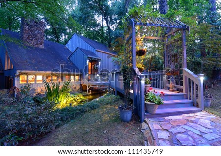 Walkway and front porch of a nice house in the woods.