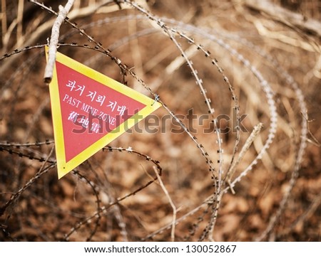 A sign indicating the end of a landmine zone in South Korea, a poignant reminder of the unresolved conflict in the region.