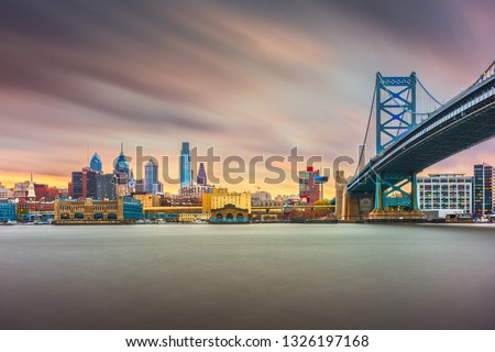 Philadelphia, Pennsylvania, USA skyline on the Delaware river with Ben Franklin Bridge at night.