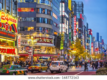 TOKYO, JAPAN - DECEMBER 15, 2012: Crowds walk under billboards in Shinjuku\'s Kabuki-cho district. The area is a nightlife district known as Sleepless Town.