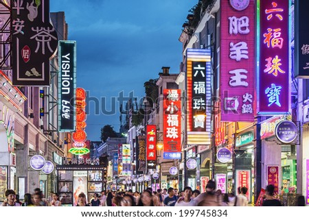 GUANGZHOU, CHINA - MAY 25, 2014: Pedestrians pass through Shangxiajiu Pedestrian Street. The street is the main shopping district of the city and a major tourist attraction.