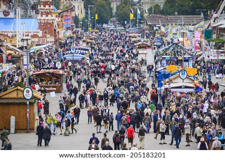 MUNICH, GERMANY - SEPTEMBER 30, 2013: Visitors explore the Theresienwiese Oktoberfest fair grounds. The 16 day festival has been annually celebrating beer since 1810.