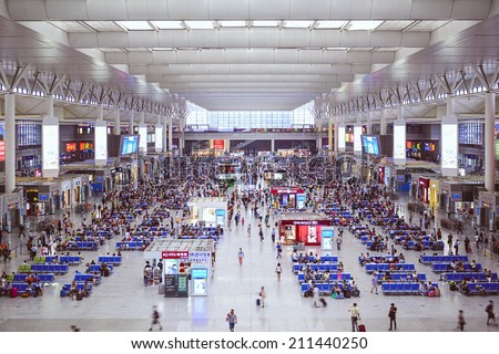 SHANGHAI, CHINA - JUNE 23, 2014: Passengers wait for trains in Shanghai Hongqiao Railway Station. It is the largest railway station in Asia with an area of 1.3 million square meters.