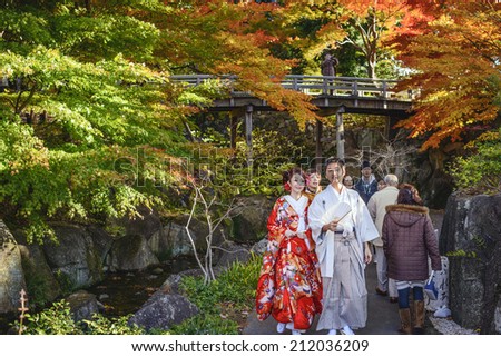 NAGOYA, JAPAN - NOVEMBER 27, 2012: A Japanese couple enjoy fall foliage while dressed in traditional garments.