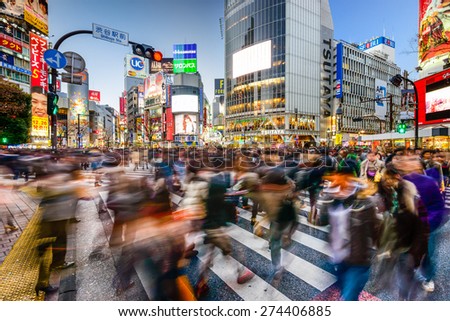 TOKYO, JAPAN - DECEMBER 14, 2012: Pedestrians walk at Shibuya Crossing during the holiday season. The scramble crosswalk is one of the largest in the world.