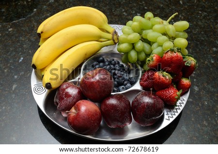 Fruit platter consisting of bananas, apples, blueberries, grapes, and strawberries.