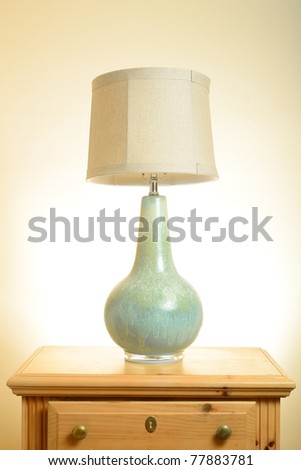 A lamp on a wooden end table.