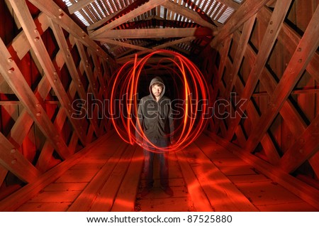 sinister guy surrounded by red light in a spooky tunnel