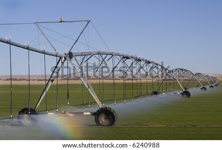 Farm Field Irrigation System watering the field, with small rainbow