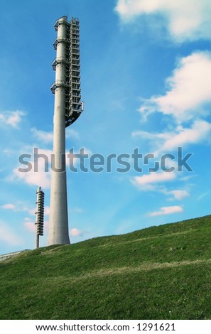 Two floodlight towers between sky and Earth