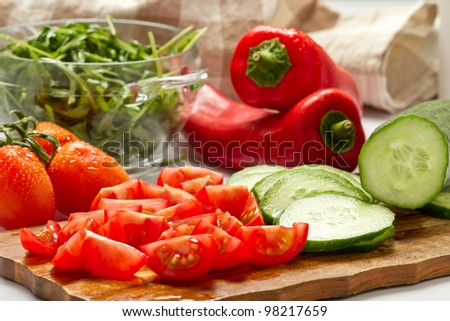Cut vegetables, salad ingredients on wood board