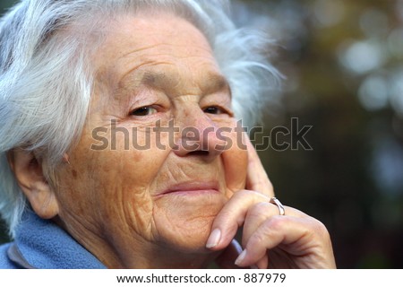 an elderly - 89 year old - woman looking into the camera and smiling. Shallow DOF.