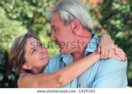 A woman in her fifties/sixties hugging her man.