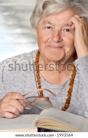 Elderly adorable woman with the book smiles