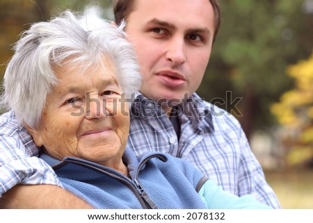 Elderly woman and young man sitting on the bench