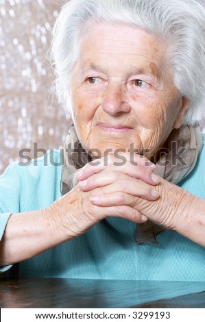Woman in her nineties with her hands clasped under the chin