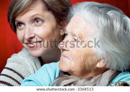 Elderly woman with her daughter. Focus on the elderly woman.
