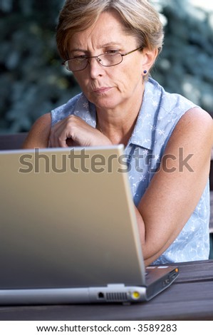 Mid adult woman solving problem on the computer